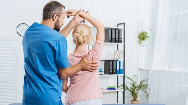 Médico e fisioterapeuta realizando mobilização de ombro em paciente durante reabilitação na SUORT, Perdizes, SP