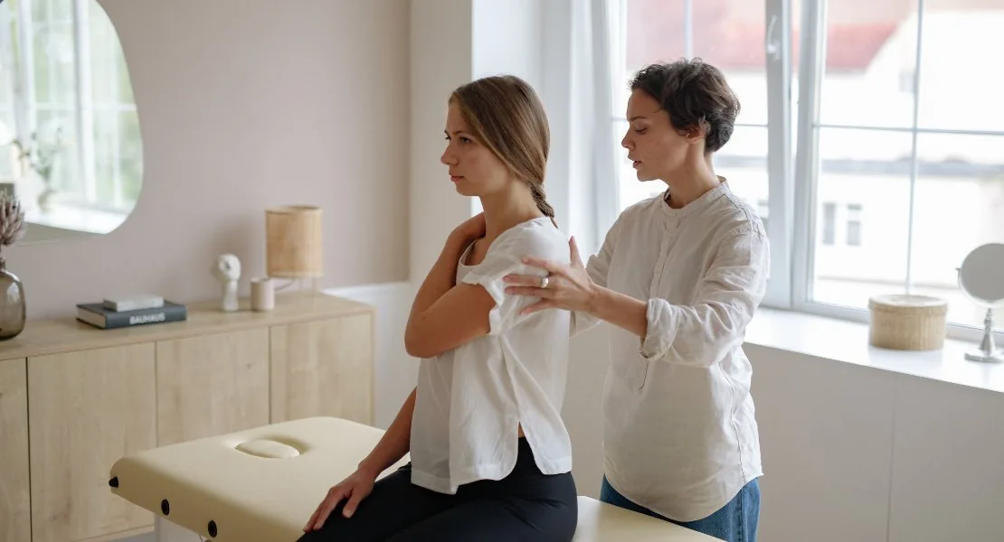 Fisioterapeuta realizando tratamento de reabilitação no ombro de uma paciente